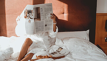 Frau genießen Winterurlaub im Halsital im Bett