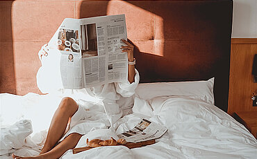 Frau genießen Winterurlaub im Halsital im Bett