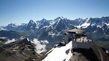 [Translate to Englisch:] Schilthorn Gipfelstation und umliegendes Bergpanorama, Luftaufnahme