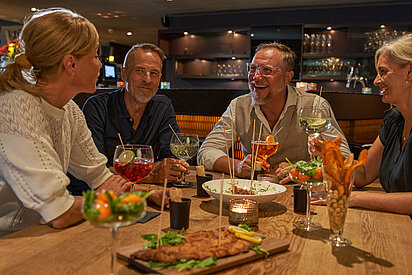 Gruppe bei einer ausgelassenen Stimmung im Bistro im Hotel Victoria in Meiringen